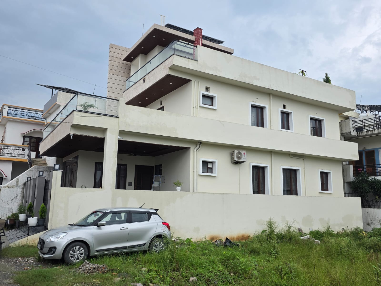 The Sajwan Residence - completed residence real construction photo showing layered terraces, stone facade planes, glass balcony edges and warm contemporary detailing